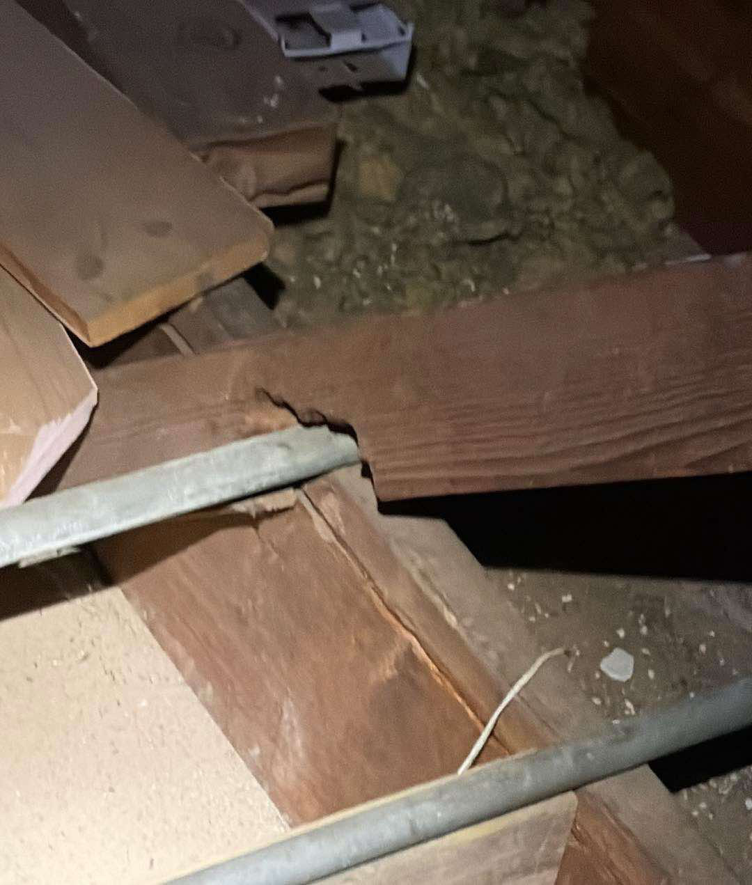 Attic truss member cut and separated above a metal brace