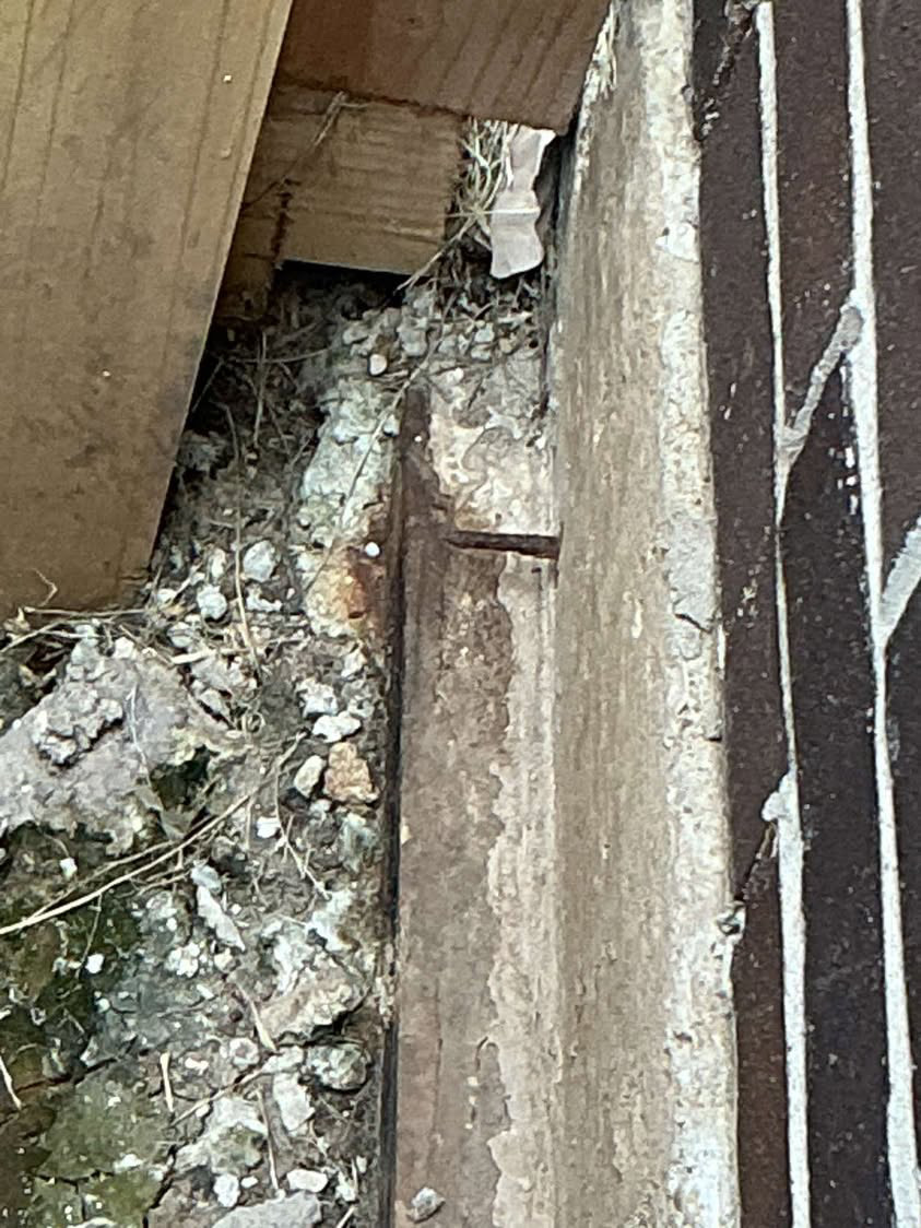 Gap between wood framing and the concrete foundation with debris